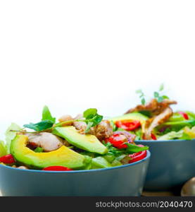 fresh and healthy Chicken Avocado salad over rustic wood table