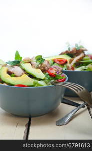 fresh and healthy Chicken Avocado salad over rustic wood table