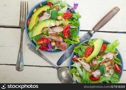 fresh and healthy Chicken Avocado salad over rustic wood table