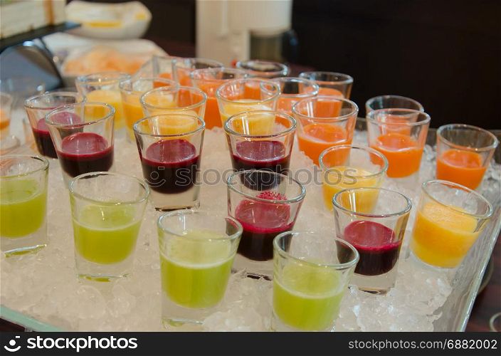 Fresh and healthy fruit juice in cups on cold ice