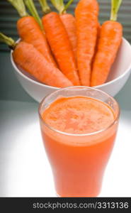 fresh and healty carrot juice unfiltered over a light table