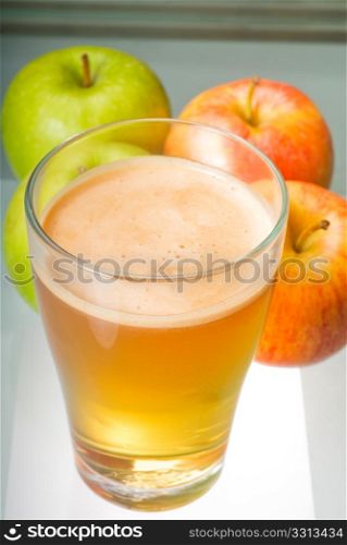 fresh and healty natural apple juice unfiltered , backlit on a light table