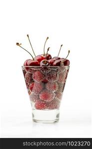 Fresh and natural red cherries in a glass with water and bubbles