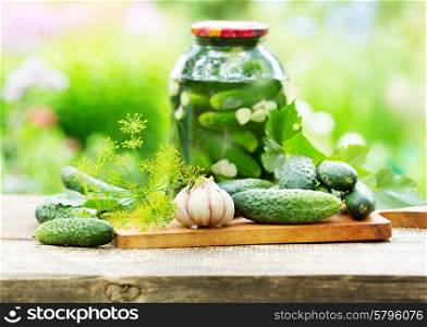 fresh and pickled cucumbers on wooden table
