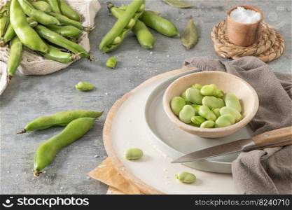Fresh and raw green broad beans on kitchen table