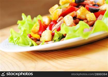 Fresh and tasty salad on plate, wooden table