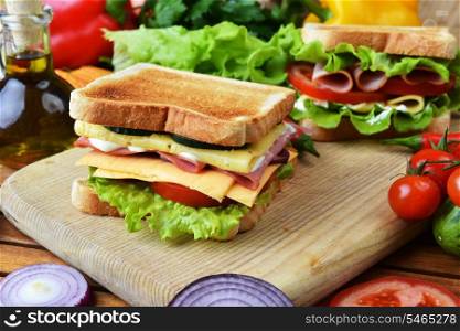 Fresh and tasty sandwich on wooden cutting board