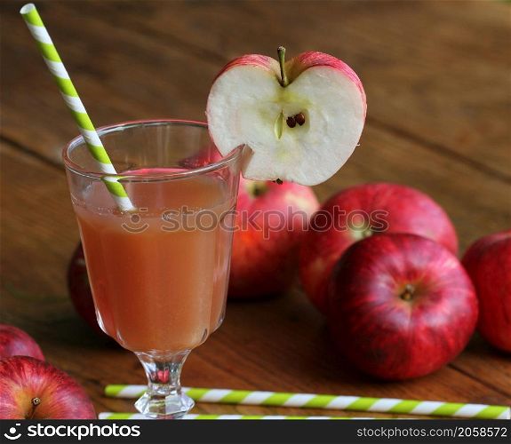 Fresh apple juice in glass with red apple on rustic wooden table .Selective Focus,