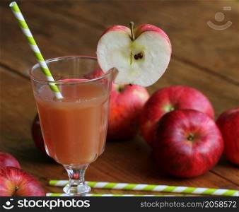 Fresh apple juice in glass with red apple on rustic wooden table .Selective Focus,