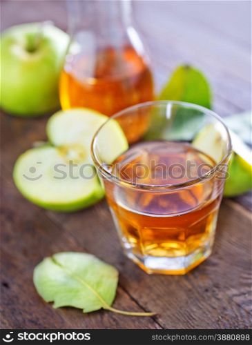 fresh apple juice in the glass and on a table
