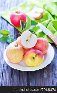 fresh apples on plate and on a table