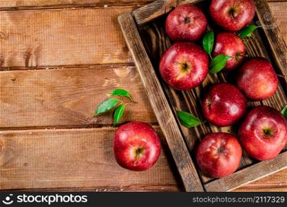 Fresh apples with leaves on the tray. On a wooden background. High quality photo. Fresh apples with leaves on the tray.
