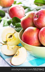 fresh apples with leaves on wooden table