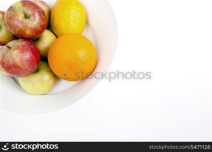 Fresh apples with orange and lemon in plate against white background