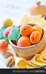 fresh apricot in wooden bowl and on a table