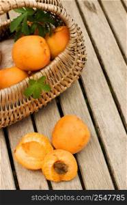 Fresh apricots in basket over wooden table