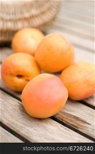 Fresh apricots in basket over wooden table