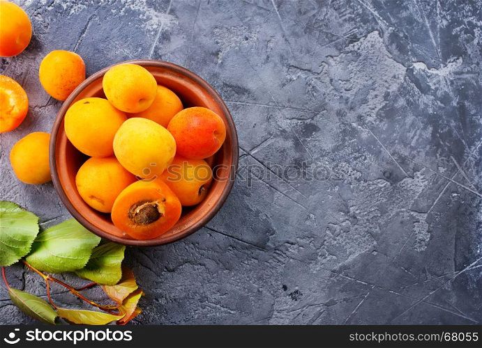 fresh apricots in bowl and on a table