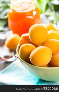 fresh apricots with leafs and jar of jam