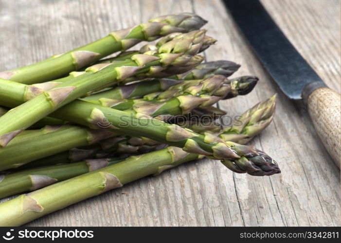 Fresh Asparagus Laid Out On A Rustic Kitchen Table With A Vegetable Knife