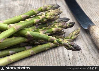 Fresh Asparagus Laid Out On A Rustic Kitchen Table With A Vegetable Knife