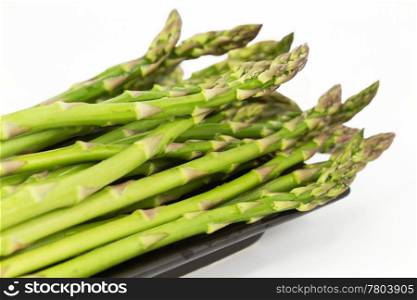 Fresh asparagus spears, close up on long, dark dish