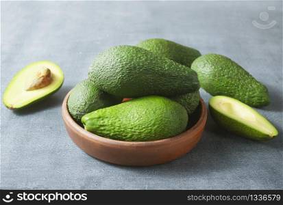 fresh avocado in brown bowl, green avocado