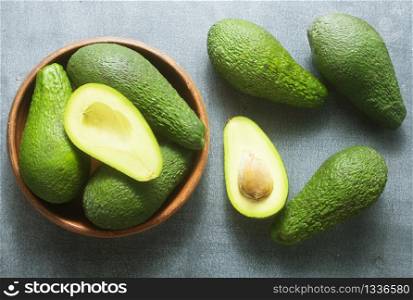 fresh avocado in brown bowl, green avocado