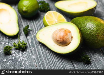 Fresh avocado, lime, parsley and salt on old blue wooden background. Avocado and lime