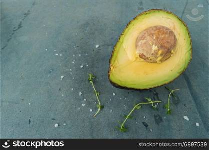 Fresh avocado sliced over vintage background close up. Ripe green avocado fruit on cement board.