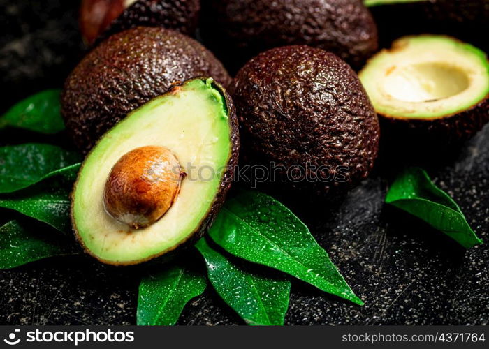 Fresh avocado with leaves. On a black background. High quality photo. Fresh avocado with leaves. On a black background.