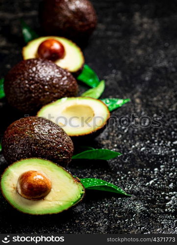 Fresh avocado with leaves. On a black background. High quality photo. Fresh avocado with leaves. On a black background.