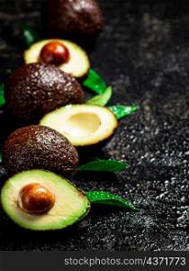 Fresh avocado with leaves. On a black background. High quality photo. Fresh avocado with leaves. On a black background.
