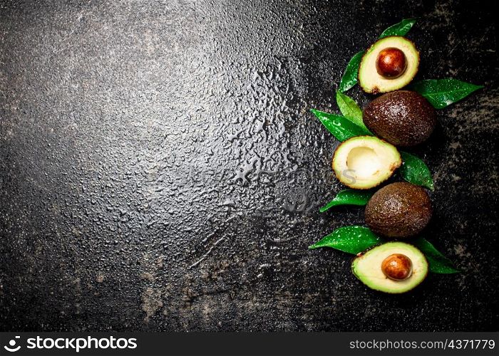 Fresh avocado with leaves. On a black background. High quality photo. Fresh avocado with leaves. On a black background.