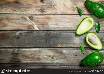 Fresh avocado with leaves. On a wooden background.. Fresh avocado with leaves.