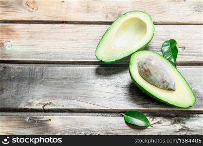 Fresh avocado with leaves. On a wooden background.. Fresh avocado with leaves.