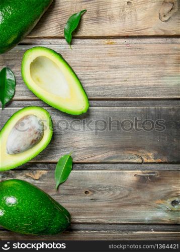 Fresh avocado with leaves. On a wooden background.. Fresh avocado with leaves.
