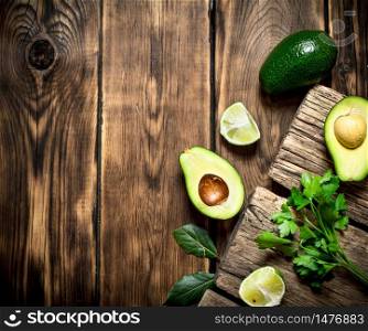 Fresh avocado with lime. On a wooden background.. Fresh avocado with lime. On wooden background.