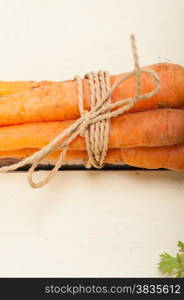 fresh baby carrots bunch tied with rope on a rustic table