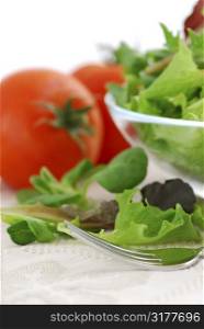 Fresh baby greens salad and tomatoes close up