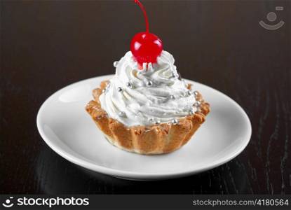 fresh baked cherry cupcake on a dark wooden background