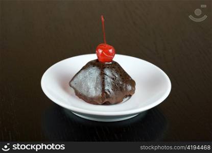 fresh baked cherry cupcake on a wooden table