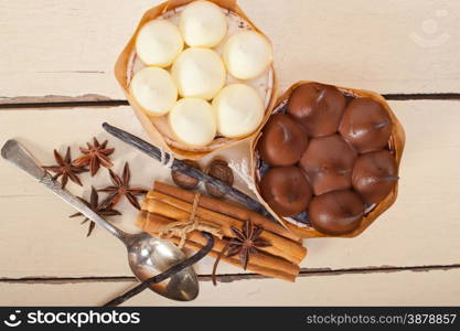 fresh baked chocolate vanilla and spices cream cake dessert over rustic wood table