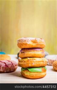 fresh baked homemade colorful donuts on light wooden background