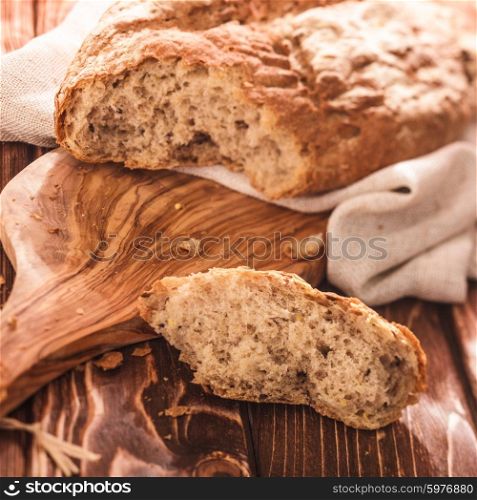Fresh-baked loaf of bread on wooden cutting board. Fresh homemade bread