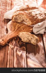 Fresh-baked loaf of bread on wooden cutting board. Fresh homemade bread