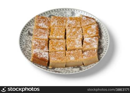 Fresh baked Moroccan yogurt cake cut into pieces on white background