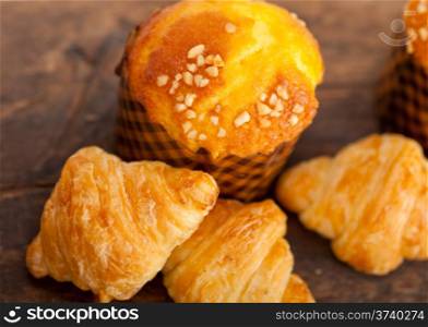 fresh baked muffin and croissant mignon on old wood table