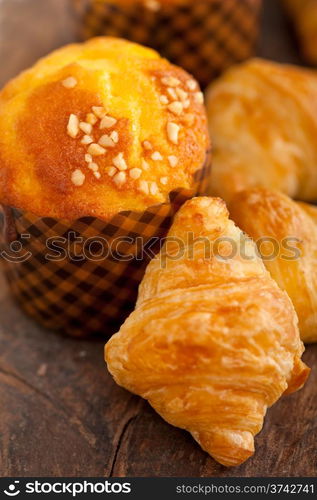 fresh baked muffin and croissant mignon on old wood table