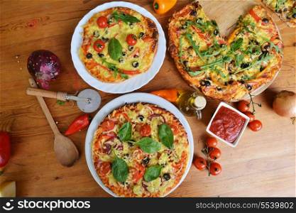fresh baked pizza with olives and peppers on table